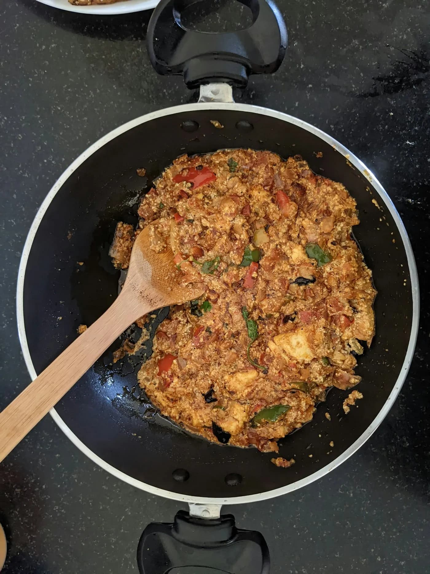 Bhurji being cooked in a pan with a wooden spatula